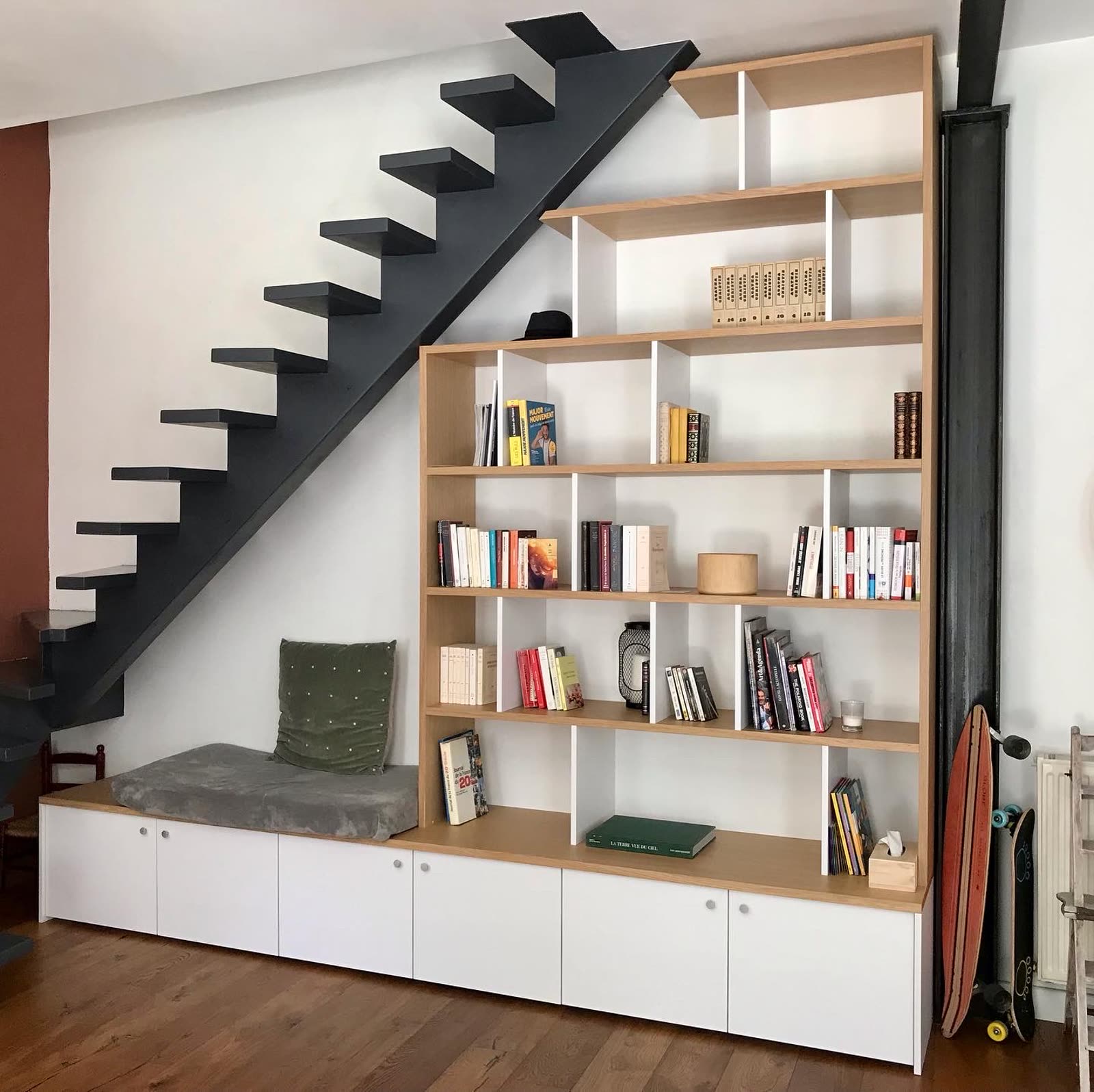 Bibliothèque sur mesure intégrée sous un escalier noir