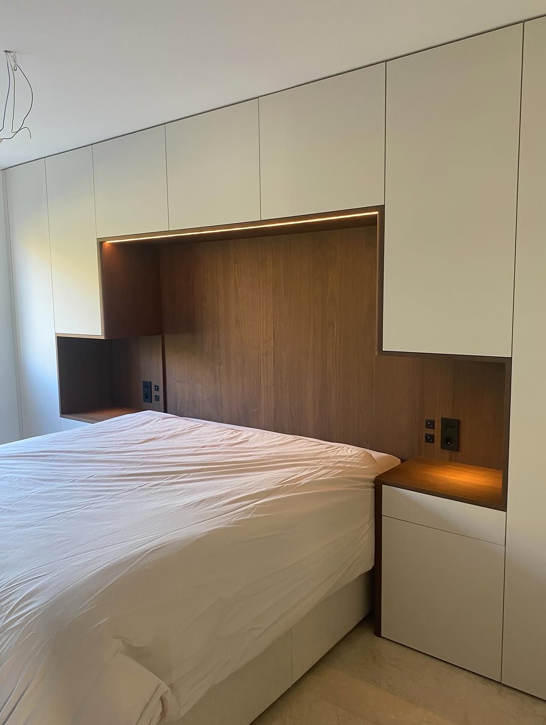 Aménagement de chambre avec tête de lit et rangements intégrés